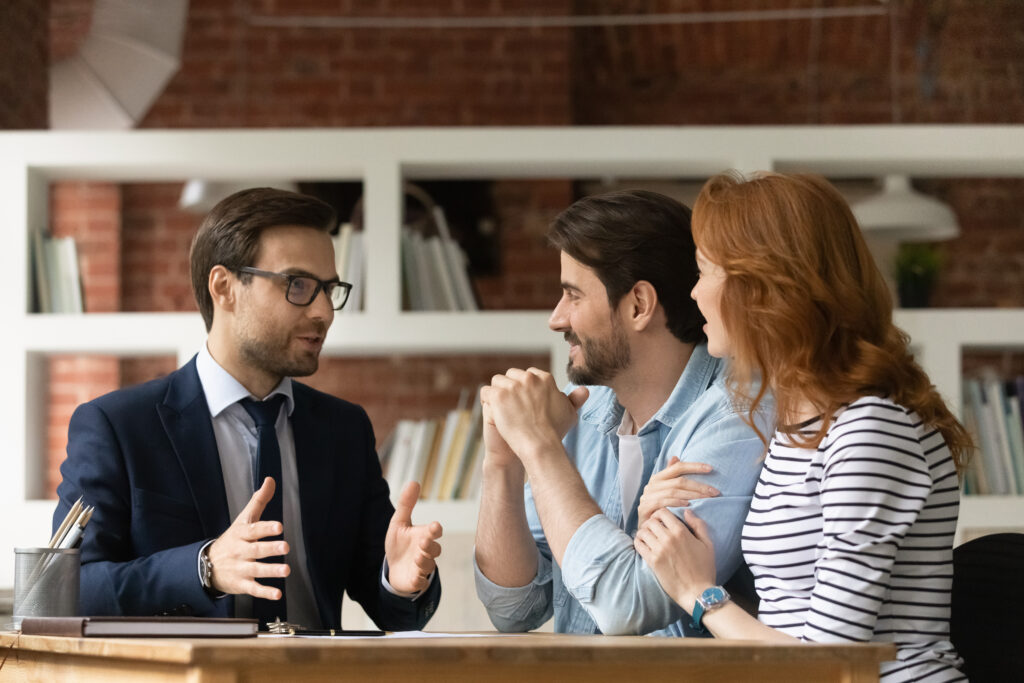 real estate agent and couple in meeting