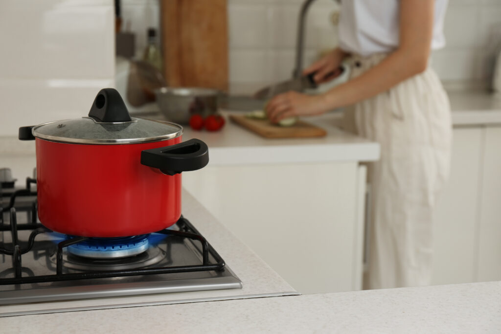 woman cooking in kitchen with gas hob