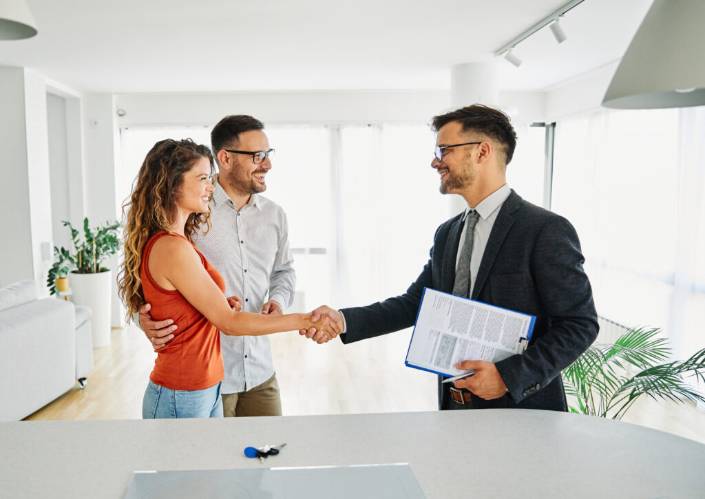 couple and lettings agent shaking hands on rental agreement